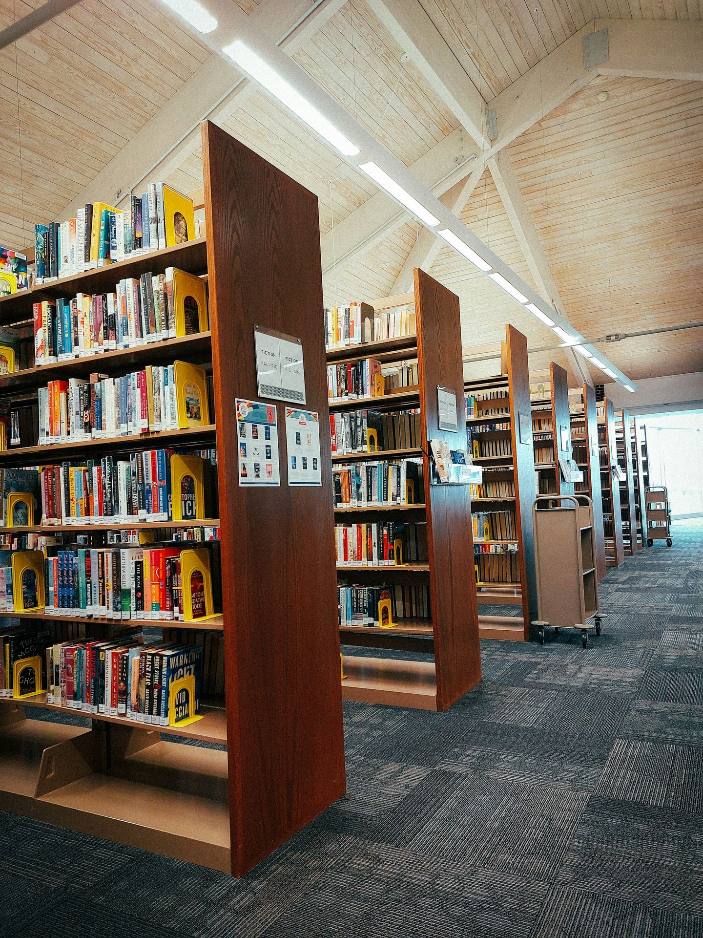 a row of wooden bookshelves filled with lots of books